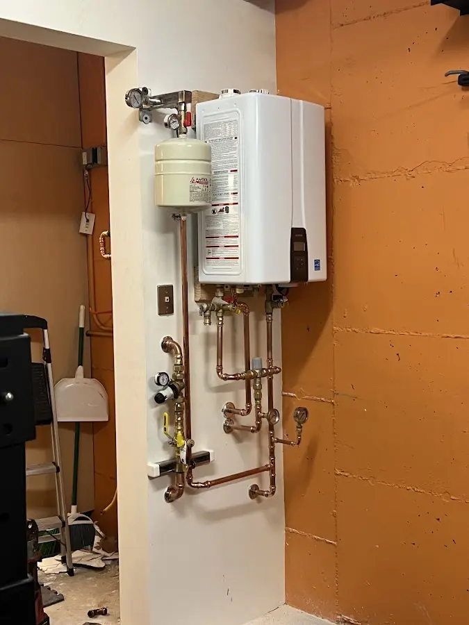 Plumbing technician inspecting water heater connections in Sorgho